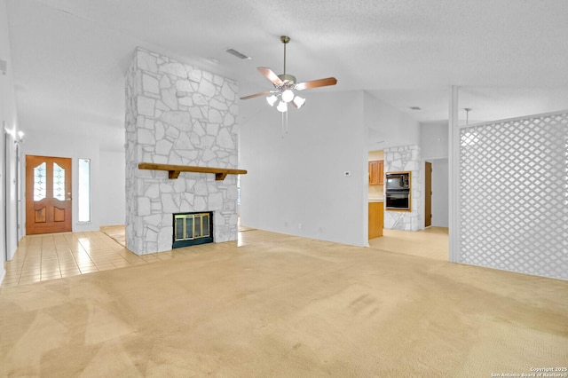 unfurnished living room with light colored carpet, ceiling fan, visible vents, and a stone fireplace