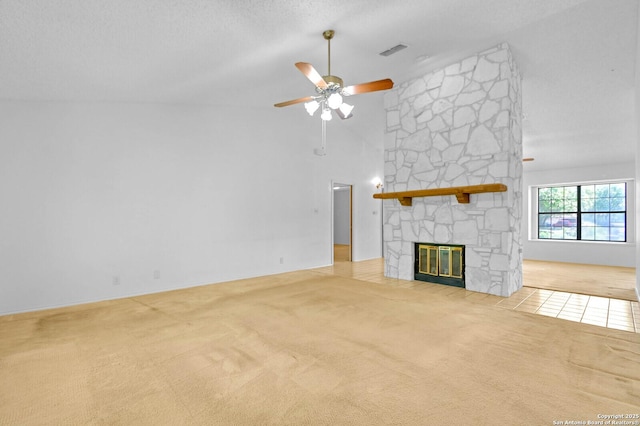unfurnished living room featuring carpet, ceiling fan, a stone fireplace, visible vents, and high vaulted ceiling