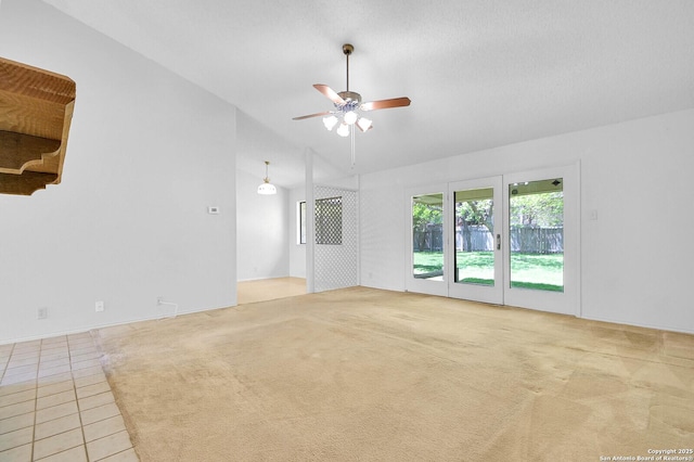 tiled empty room featuring carpet, ceiling fan, and lofted ceiling