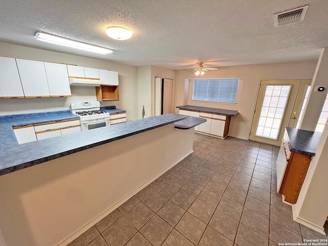 7514 Autumn Ledge, Converse, TX 78109 - kitchen with dark countertops, visible vents, and white range with gas cooktop