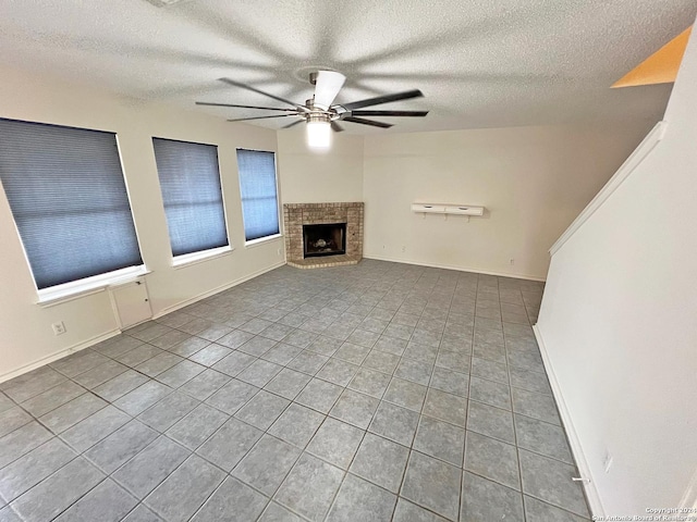 7514 Autumn Ledge, Converse, TX 78109 - unfurnished living room featuring tile patterned flooring, ceiling fan, a fireplace, baseboards, and a textured ceiling