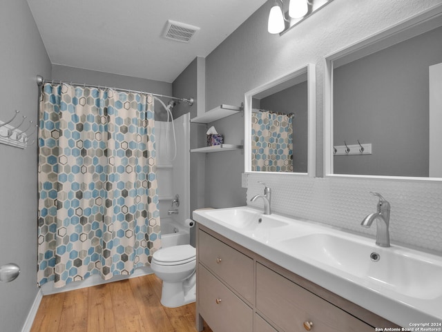 bathroom featuring wood finished floors, visible vents, shower / bath combo, and a sink