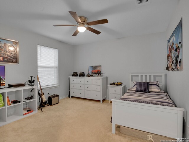 bedroom featuring visible vents, a ceiling fan, and light carpet