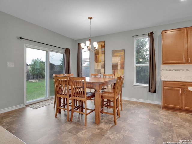 dining space with an inviting chandelier, baseboards, and plenty of natural light