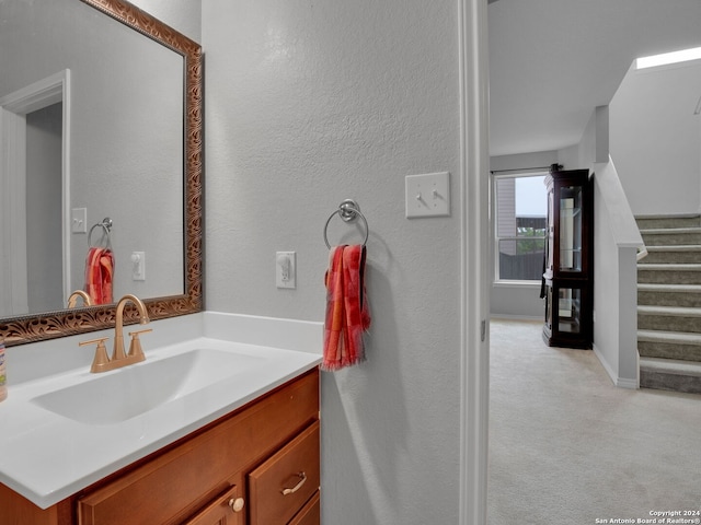 bathroom with a textured wall and vanity