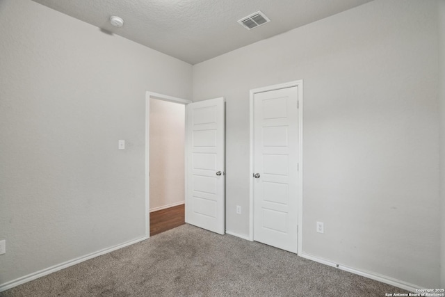 unfurnished bedroom featuring visible vents, baseboards, and carpet floors