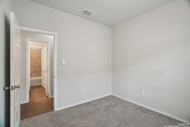 carpeted empty room with visible vents and baseboards