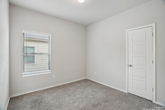 unfurnished room featuring baseboards and carpet