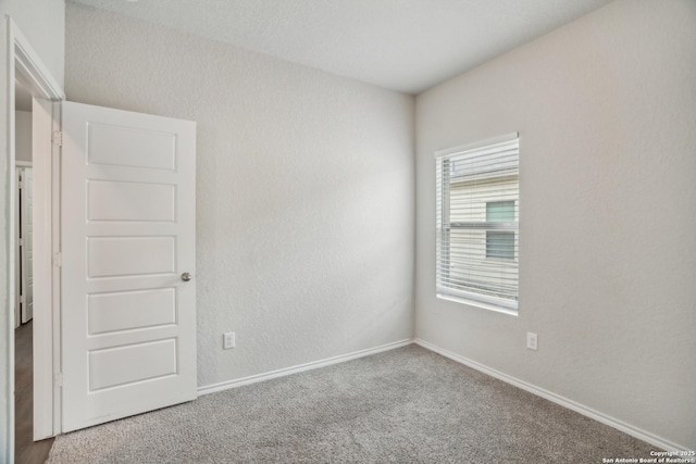 empty room with carpet and baseboards
