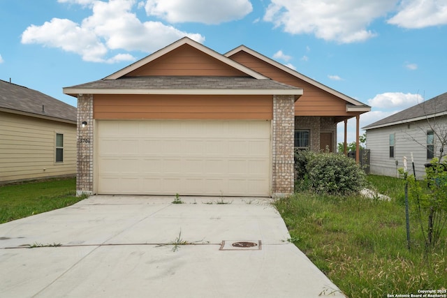 single story home with concrete driveway, a shingled roof, an attached garage, and brick siding
