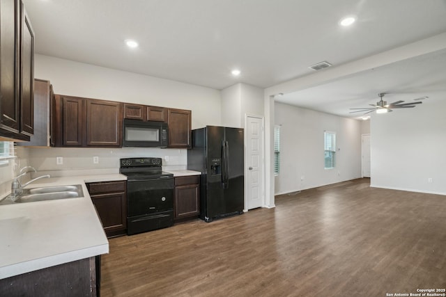 kitchen with a sink, black appliances, visible vents, light countertops, and dark brown cabinets