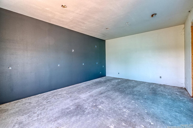 unfurnished room with unfinished concrete flooring