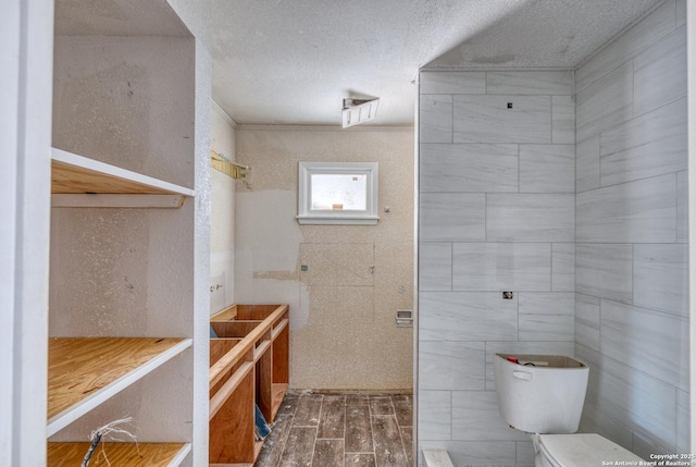 bathroom with toilet, a textured ceiling, and wood finished floors