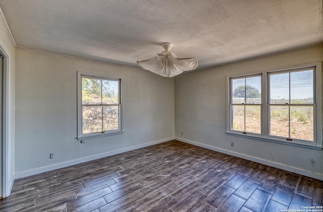 unfurnished room with dark wood-style flooring, ceiling fan, crown molding, baseboards, and a textured ceiling