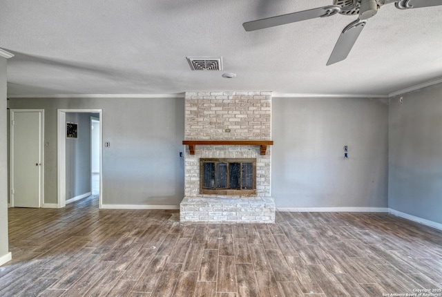 unfurnished living room featuring ornamental molding, a ceiling fan, visible vents, and wood finished floors