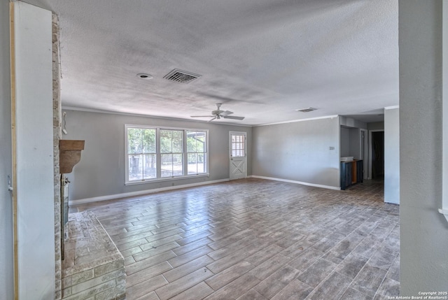 unfurnished living room with a textured ceiling, visible vents, a ceiling fan, and baseboards