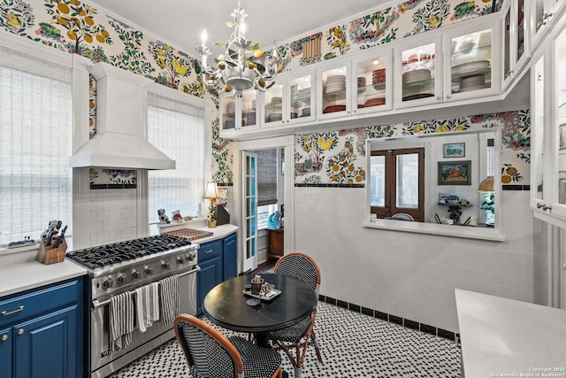 112 King William, San Antonio, TX 78204 - kitchen with blue cabinetry, custom exhaust hood, a chandelier, light countertops, and high end stove