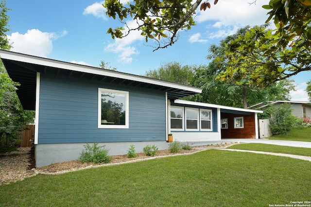 ranch-style house with fence, a carport, driveway, and a front yard