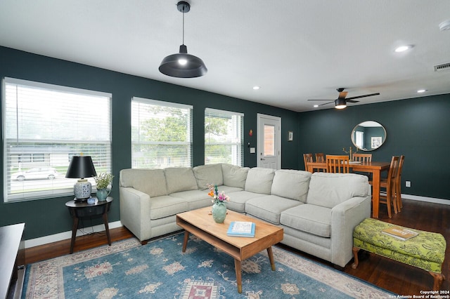 living area featuring wood finished floors, a ceiling fan, visible vents, and baseboards