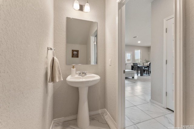 bathroom with recessed lighting, a sink, marble finish floor, a textured wall, and baseboards