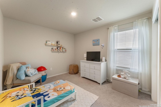 bedroom with visible vents, light carpet, and baseboards