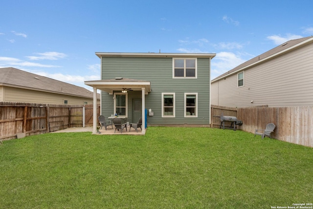 rear view of house with a lawn, ceiling fan, a patio area, and a fenced backyard