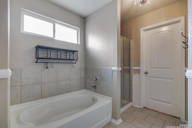 bathroom with a stall shower, a bath, and tile patterned floors