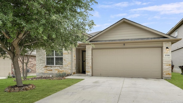 single story home featuring driveway, a garage, a front lawn, and stone siding
