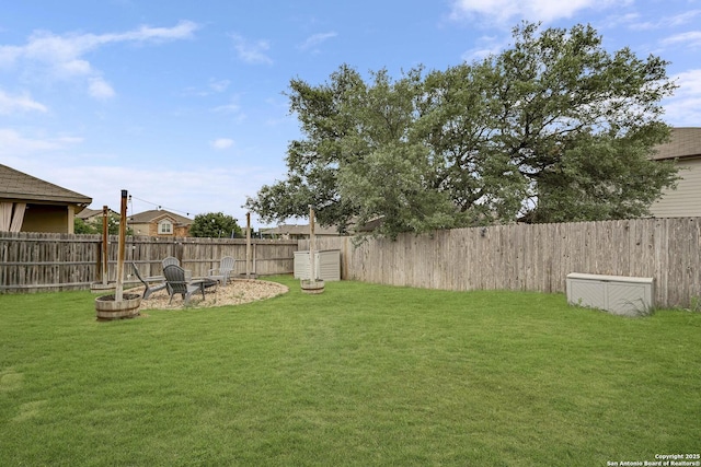 view of yard featuring a fire pit and a fenced backyard