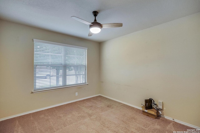 unfurnished room with baseboards, a ceiling fan, and light carpet