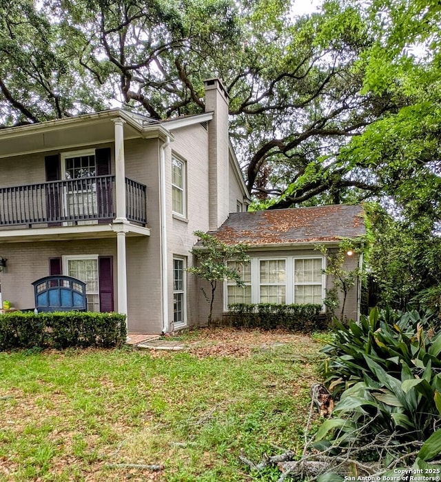 2465 Gladys St, Beaumont, TX 77702 - view of front of house featuring a chimney, a balcony, and brick siding