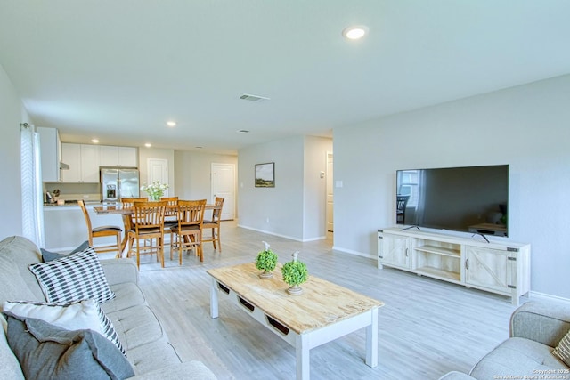 living area featuring recessed lighting, visible vents, light wood-style floors, and baseboards