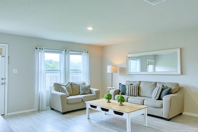 living room featuring baseboards and light wood-style flooring