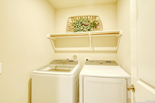 clothes washing area with washing machine and clothes dryer and laundry area