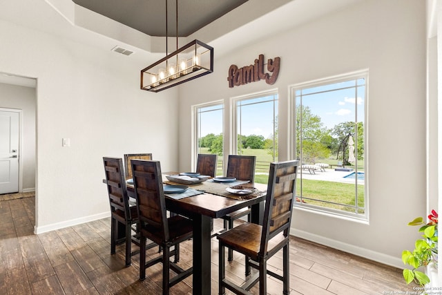 dining room featuring plenty of natural light, visible vents, wood finished floors, and baseboards