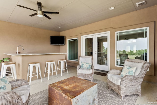 living area with visible vents, a ceiling fan, french doors, and recessed lighting