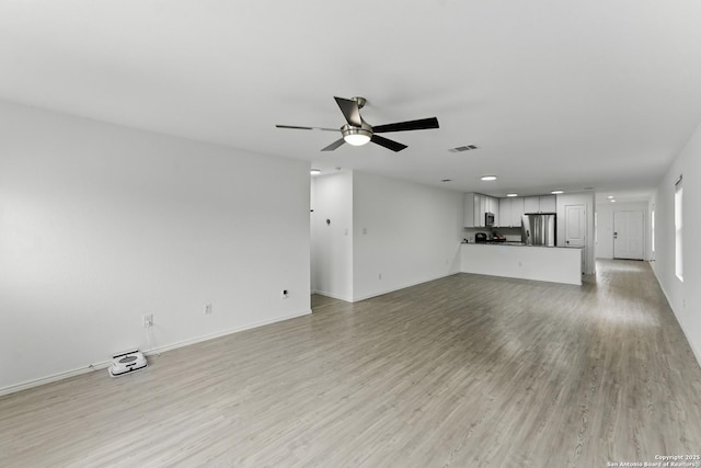unfurnished living room with baseboards, visible vents, a ceiling fan, and light wood-style floors