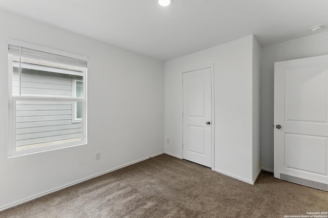 unfurnished bedroom featuring carpet flooring and baseboards