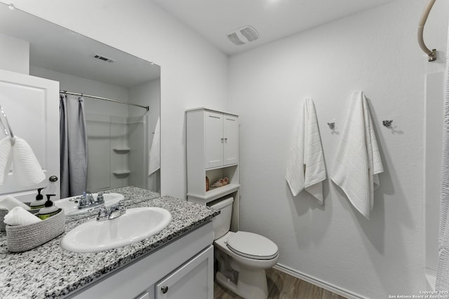 full bath with a shower with curtain, vanity, visible vents, and wood finished floors