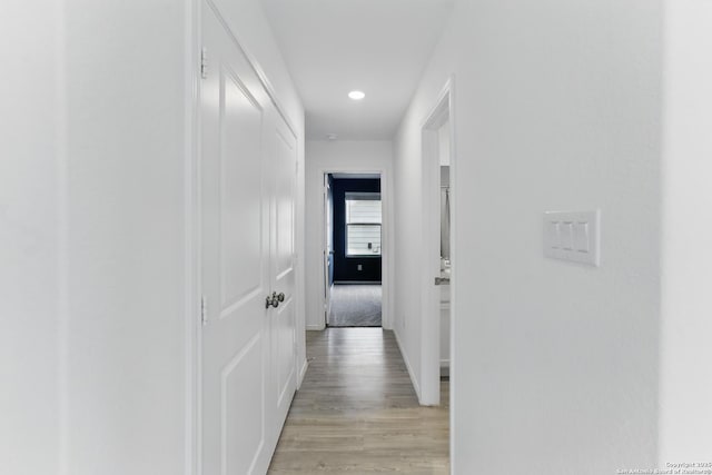 corridor featuring recessed lighting, light wood-style flooring, and baseboards