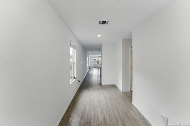 corridor featuring recessed lighting, visible vents, wood finished floors, and baseboards