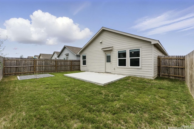 rear view of house with a patio, a fenced backyard, and a lawn