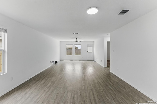 unfurnished living room with ceiling fan, baseboards, wood finished floors, and visible vents