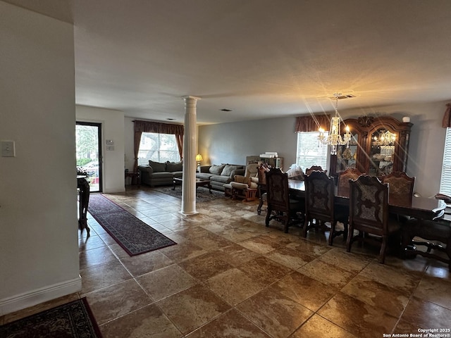 9528 Braun, San Antonio, TX 78254 - dining space with an inviting chandelier, ornate columns, stone finish floor, and baseboards