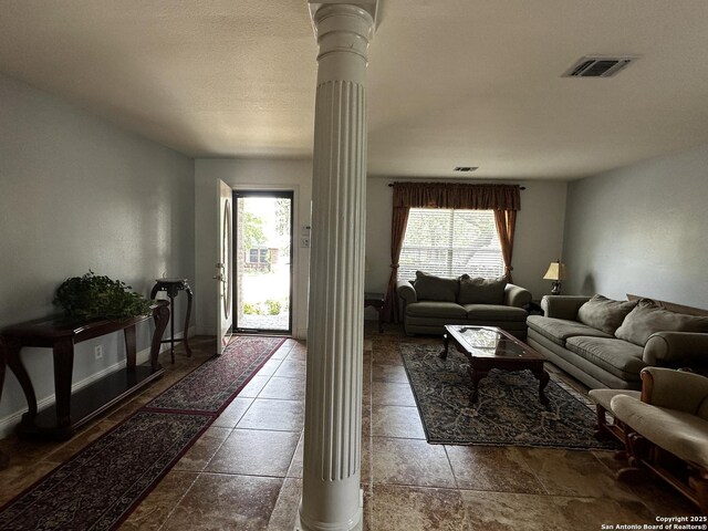 9528 Braun, San Antonio, TX 78254 - living area with stone tile floors, visible vents, decorative columns, and a wealth of natural light