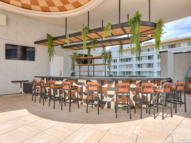 bar with tile patterned flooring and a towering ceiling