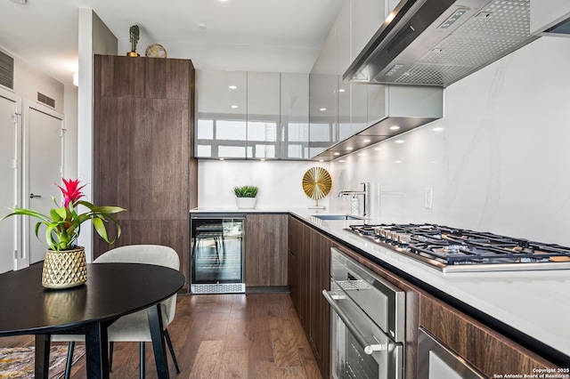 kitchen with modern cabinets, extractor fan, stainless steel appliances, and beverage cooler