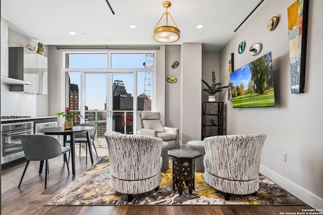 living area with recessed lighting, wood finished floors, and baseboards