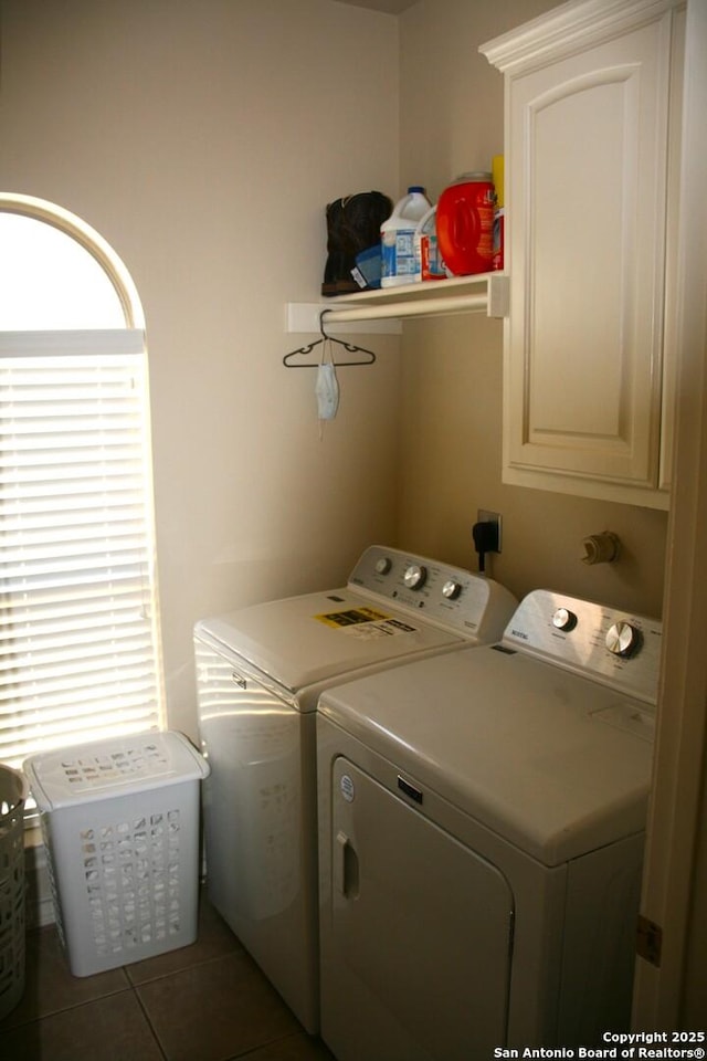 laundry room with light tile patterned flooring, cabinet space, and washing machine and clothes dryer