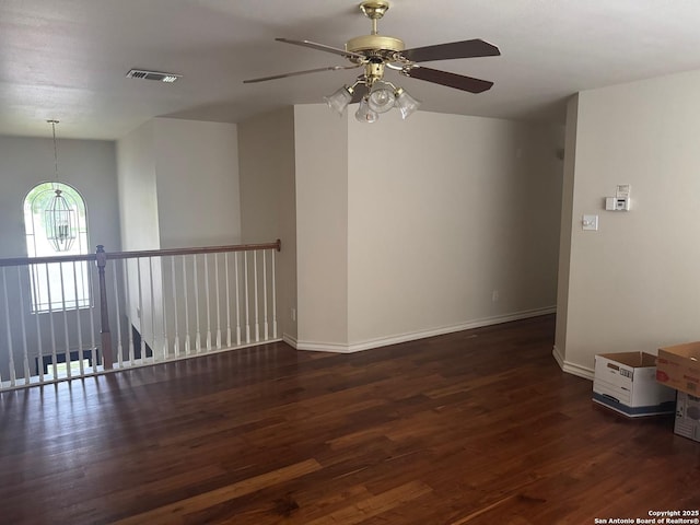 empty room featuring wood finished floors, visible vents, ceiling fan, and baseboards